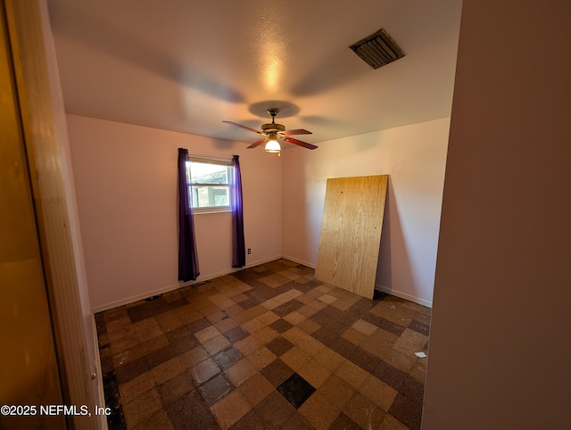 unfurnished room featuring ceiling fan, visible vents, and baseboards