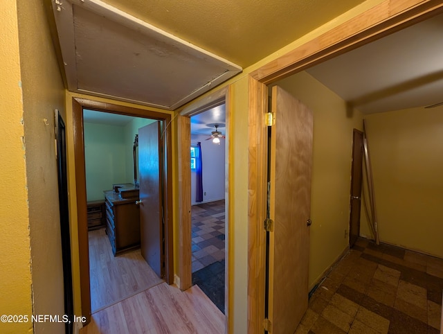 hall with attic access and tile patterned floors