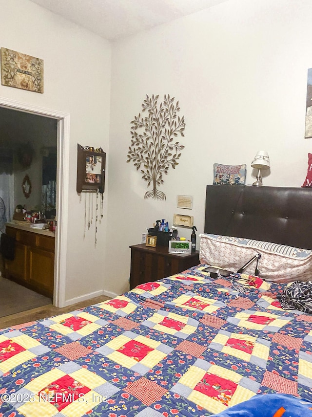 bedroom featuring baseboards and ensuite bathroom