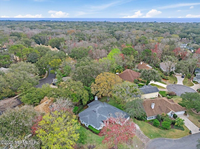 birds eye view of property featuring a forest view