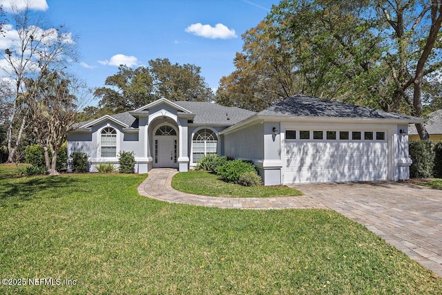 single story home featuring a garage, stucco siding, roof with shingles, decorative driveway, and a front yard