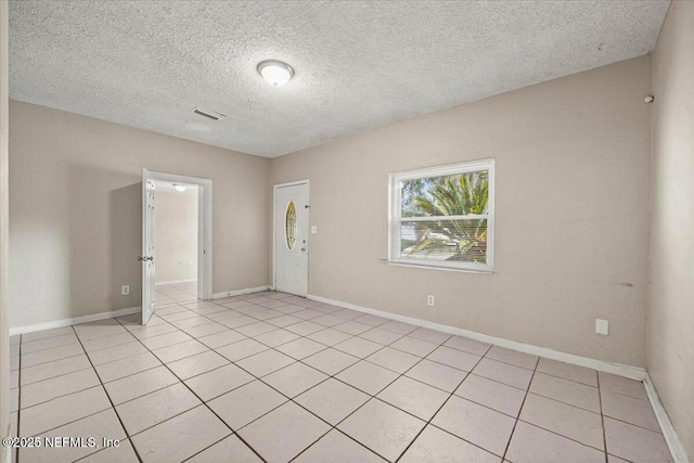 unfurnished room featuring light tile patterned floors, baseboards, and visible vents