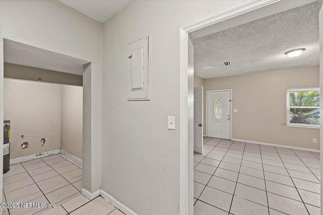 washroom with visible vents, baseboards, a textured ceiling, and light tile patterned flooring