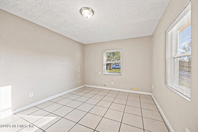 empty room featuring baseboards and a textured ceiling