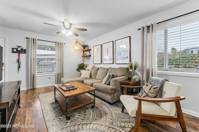 living room featuring dark wood-type flooring, a wealth of natural light, ceiling fan, and a textured ceiling