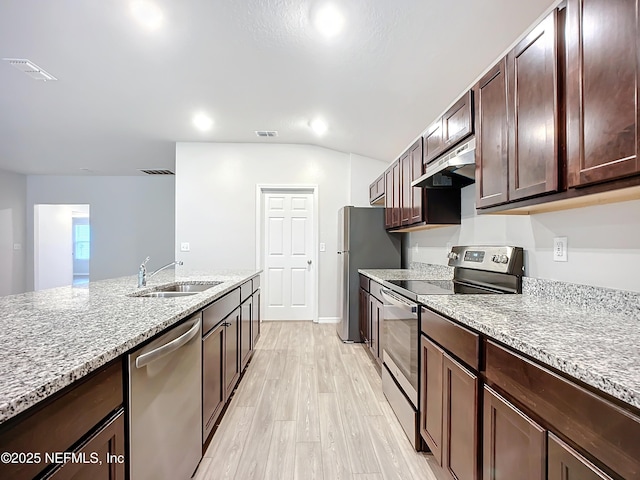 kitchen with stainless steel appliances, visible vents, light wood-style flooring, a sink, and under cabinet range hood