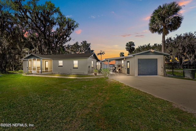 ranch-style home featuring driveway, an attached garage, and a front lawn