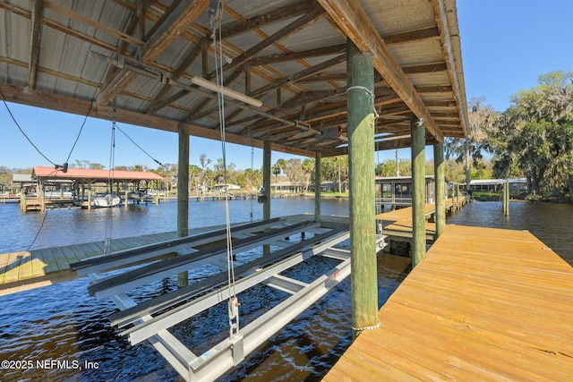 dock area with a water view and boat lift