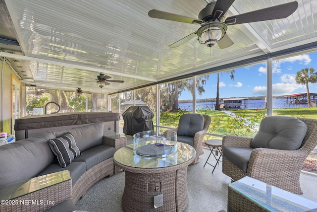 sunroom / solarium with a water view and ceiling fan