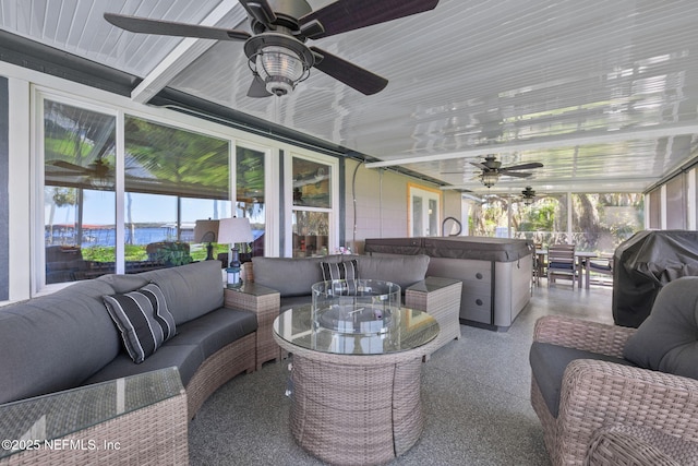 sunroom with a water view and a ceiling fan