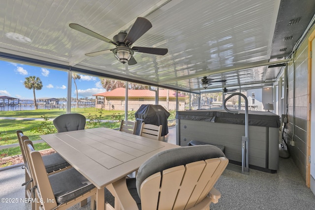 sunroom / solarium featuring ceiling fan and a water view