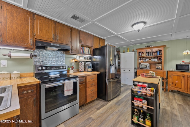 kitchen with light wood finished floors, visible vents, appliances with stainless steel finishes, under cabinet range hood, and open shelves