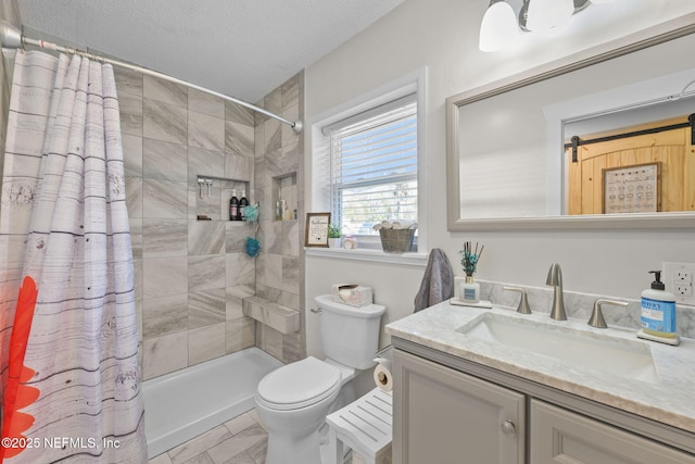 full bath with a textured ceiling, vanity, a tile shower, and toilet