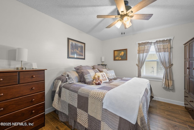 bedroom featuring dark wood-style floors, ceiling fan, baseboards, and a textured ceiling