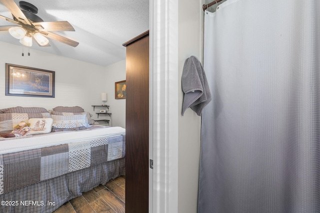 bedroom featuring a textured ceiling, a ceiling fan, and dark wood-type flooring