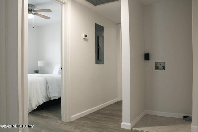 hall featuring light wood-style floors, visible vents, electric panel, and baseboards