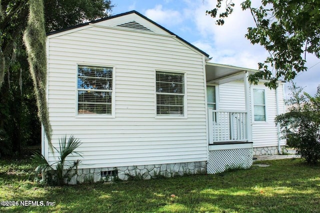 view of side of property featuring crawl space and a lawn