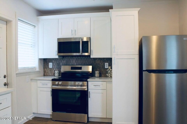 kitchen with white cabinetry, appliances with stainless steel finishes, light countertops, and backsplash