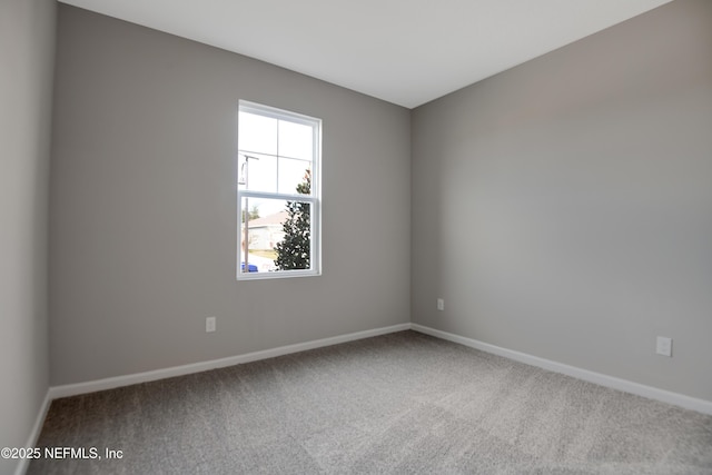 unfurnished room with baseboards and carpet flooring