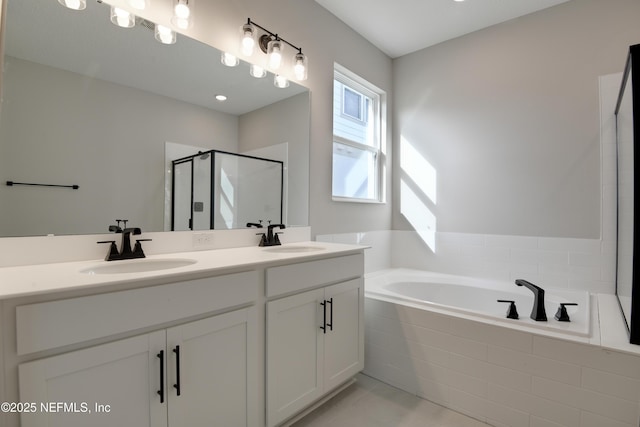 full bath with a garden tub, a sink, a shower stall, and double vanity