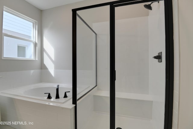 bathroom featuring a stall shower and a garden tub