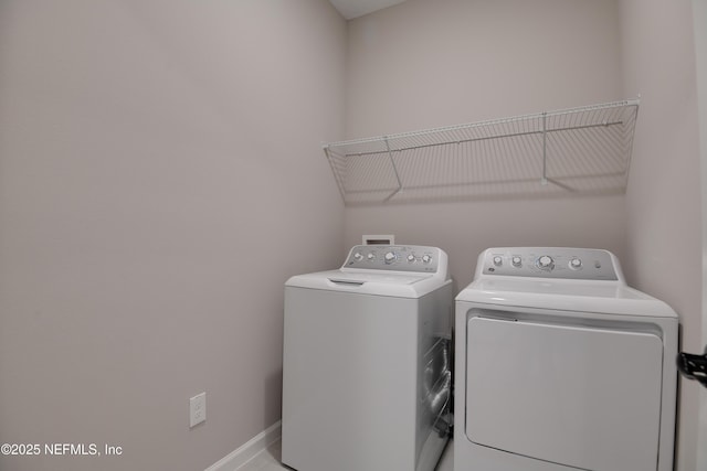 washroom with laundry area, baseboards, and independent washer and dryer