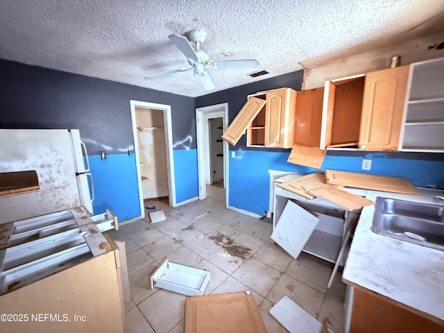 kitchen with light countertops, a sink, visible vents, and light brown cabinetry