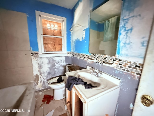 bathroom with tile walls, toilet, wainscoting, vanity, and a shower with curtain