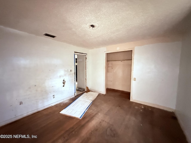 unfurnished bedroom featuring baseboards, a textured ceiling, visible vents, and a closet