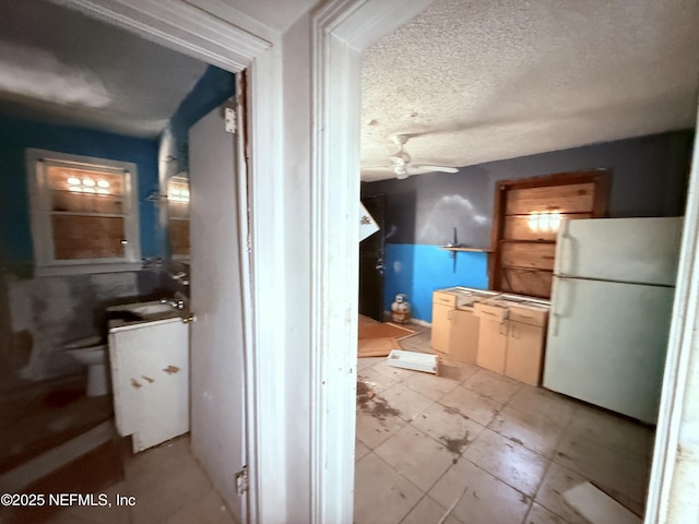 interior space with toilet, a textured ceiling, and a ceiling fan