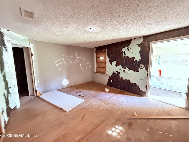 unfurnished room with a textured ceiling and visible vents