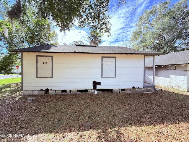 rear view of property featuring a shingled roof