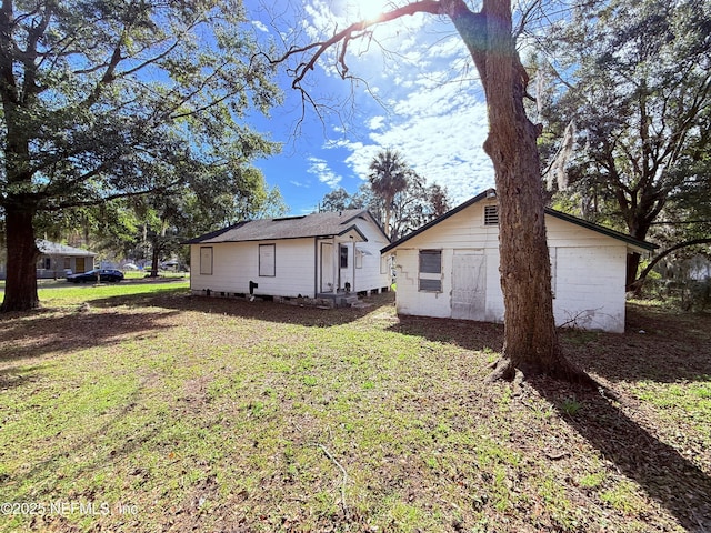 rear view of house featuring a yard