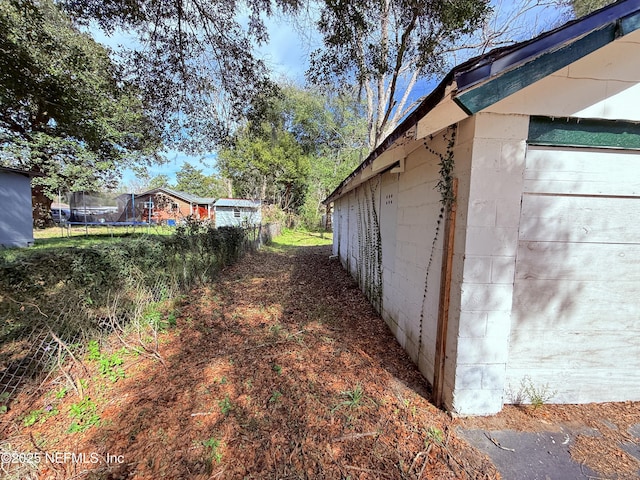 view of property exterior with a trampoline and concrete block siding