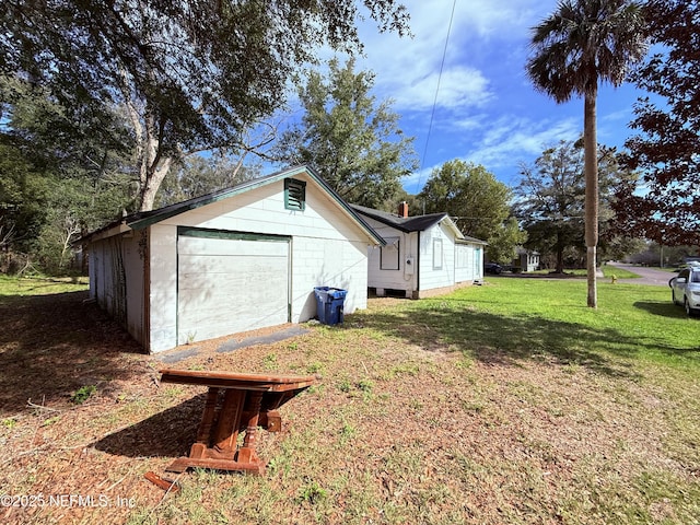 view of property exterior featuring an outbuilding, a yard, and driveway