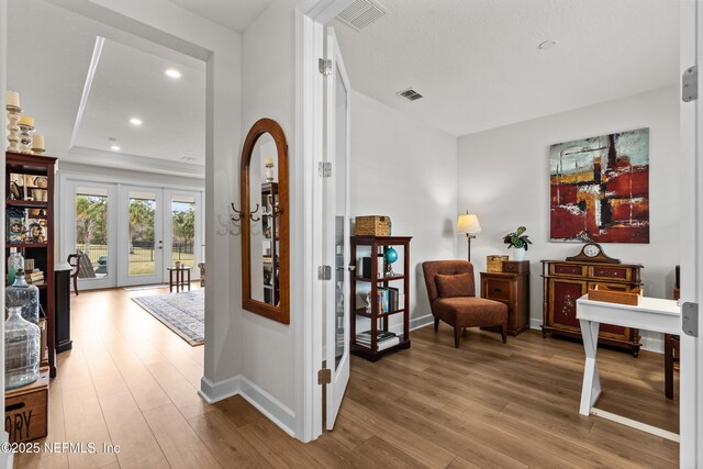 93322 Sandown Dr, Fernandina Beach, FL 32034 - hall featuring french doors, wood finished floors, baseboards, recessed lighting, and a tray ceiling