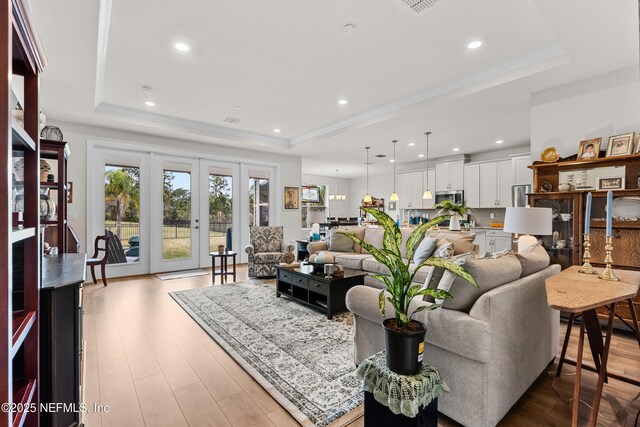 93322 Sandown Dr, Fernandina Beach, FL 32034 - living room with a raised ceiling, light wood-style floors, recessed lighting, and french doors