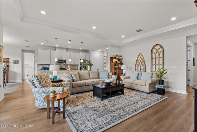 93322 Sandown Dr, Fernandina Beach, FL 32034 - living area featuring a tray ceiling, recessed lighting, light wood-style floors, baseboards, and ornamental molding