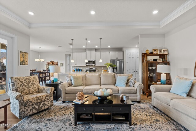 93322 Sandown Dr, Fernandina Beach, FL 32034 - living area featuring a tray ceiling, wood finished floors, crown molding, recessed lighting, and a chandelier