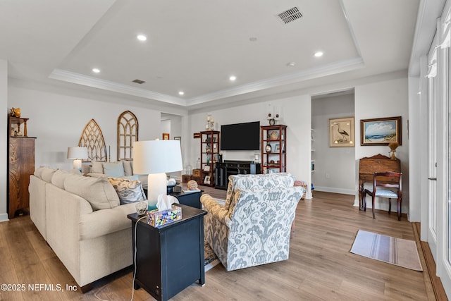 93322 Sandown Dr, Fernandina Beach, FL 32034 - living room featuring a tray ceiling, light wood finished floors, baseboards, ornamental molding, and recessed lighting