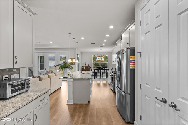 93322 Sandown Dr, Fernandina Beach, FL 32034 - kitchen featuring stainless steel appliances, recessed lighting, open floor plan, a kitchen island with sink, and light wood-style floors