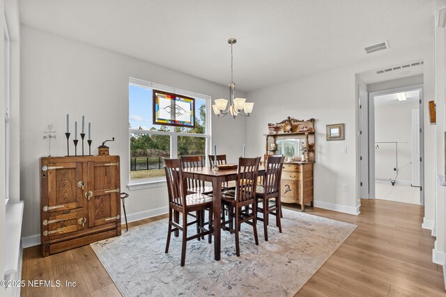 93322 Sandown Dr, Fernandina Beach, FL 32034 - dining room with a chandelier, light wood-style floors, and baseboards