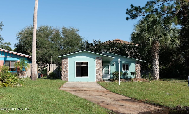 view of front of property featuring stone siding and a front yard