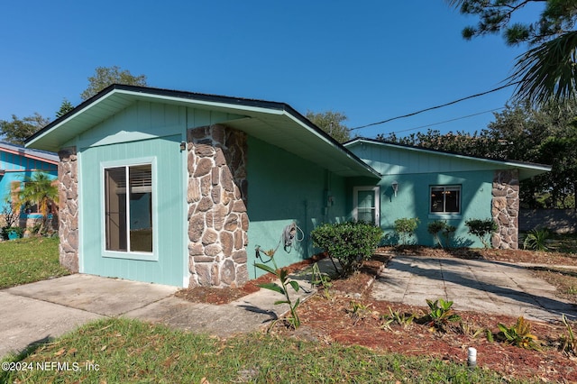 view of front of property featuring stone siding and a patio area