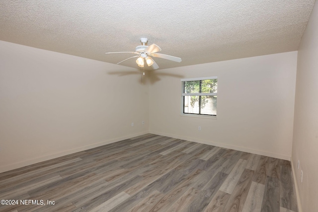 unfurnished room featuring ceiling fan, baseboards, dark wood finished floors, and a textured ceiling