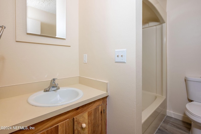 full bathroom featuring baseboards, vanity, toilet, and wood finished floors