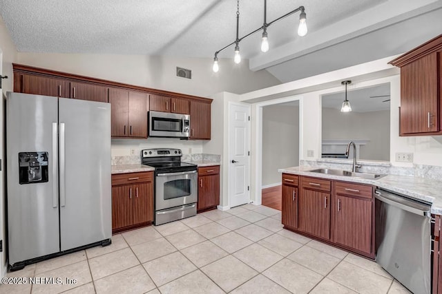 kitchen with visible vents, lofted ceiling, a sink, appliances with stainless steel finishes, and decorative light fixtures