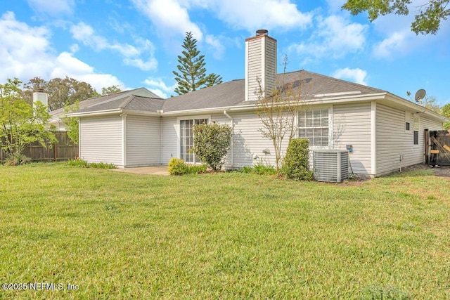 back of property featuring fence, a yard, central AC, a chimney, and a patio area