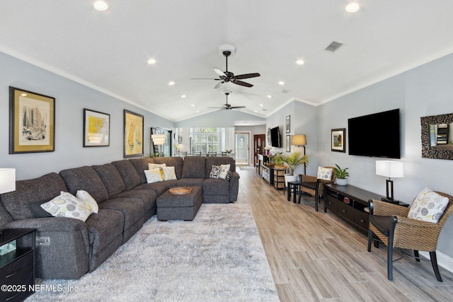 living room featuring lofted ceiling, ornamental molding, visible vents, and light wood-style flooring