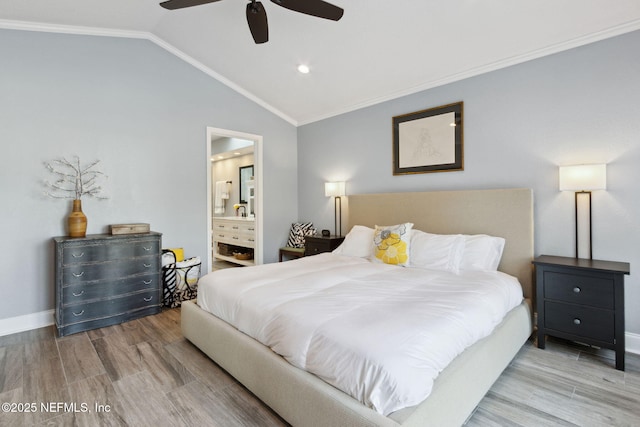 bedroom with lofted ceiling, ensuite bathroom, ornamental molding, wood finished floors, and baseboards